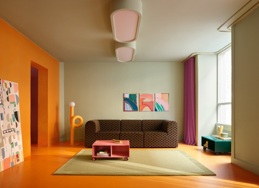 A living room with orange walls and a couch</p>
<p>Description automatically generated