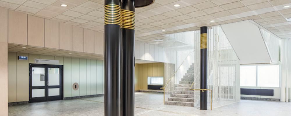 Runt några pelare på Västerviks psykiatrisjukhus sitter mässingsband som anknyter till John Bauertemat.