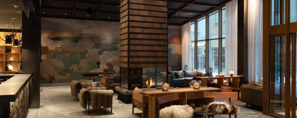 Estetiken är inspirerad av landskapsmåleri och naturens material. Specialritat undertak i skogsgrönt, trä med tydlig struktur, grova stenblock, ulltextilier och skinn skapar en taktil och varm känsla.
Foto: Gustav Svanberg