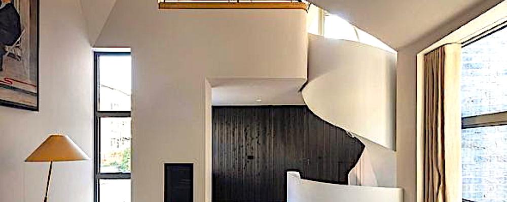 Bild: Interiören präglas av mörk träpanel, natursten och mässingsdetaljer. Ljussättningen är infälld och indirekt. Arkitekterna beskriver detta som en medveten kontrast mot den rationella och återhållsamma estetik som ofta förknippas med små bostäder. Foto: Nick Kane