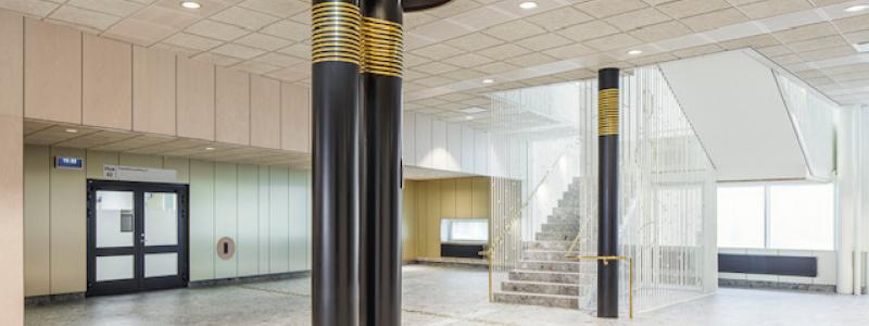 Runt några pelare på Västerviks psykiatrisjukhus sitter mässingsband som anknyter till John Bauertemat.