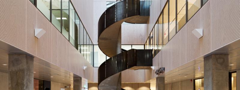 Atriet sett från plan 2. Skulptural trappa med räcke av stålplåt som förbinder labbet med mötesrummen och pausrummen. 
Bild: Mads Frederik arkitekturfotografi