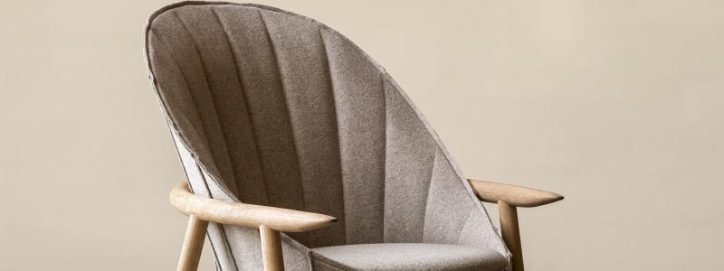 HidaHida en fåtölj i textil som svepts över en stomme av bokträ, en lika spontan som precist formulerad form. Den är har synliga trädetaljer av massiv bok eller ek. Rygg och sits med klädsel i tyg eller läder.design Kengo Kuma 2024 Foto: Lennart Durehed/ Gärsnäs