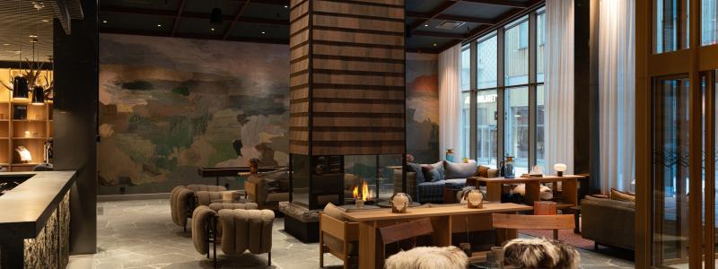 Estetiken är inspirerad av landskapsmåleri och naturens material. Specialritat undertak i skogsgrönt, trä med tydlig struktur, grova stenblock, ulltextilier och skinn skapar en taktil och varm känsla.
Foto: Gustav Svanberg