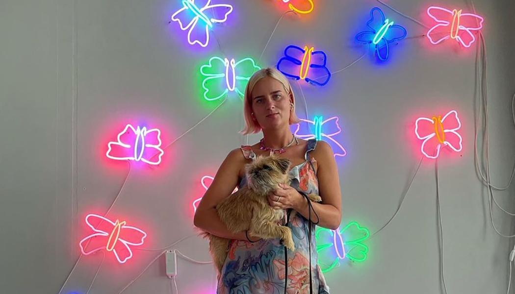 Neonkonstnären Josefin Eklund framför sitt verk Flower. Foto: Designtorget