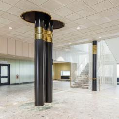 Runt några pelare på Västerviks psykiatrisjukhus sitter mässingsband som anknyter till John Bauertemat.