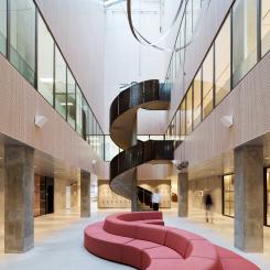 Atriet sett från plan 2. Skulptural trappa med räcke av stålplåt som förbinder labbet med mötesrummen och pausrummen. 
Bild: Mads Frederik arkitekturfotografi